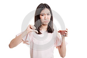 Asian woman thumbs down hate tomato juice.