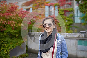 asian woman toothy smiling face with colorful leaves park background