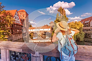 Asian woman tourist enjoying sunset view of the old town of Nurnberg city and Pegnitz river. Travel and student lifestyle in