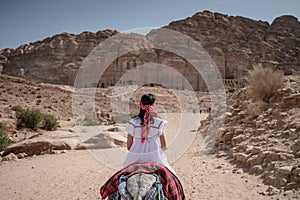 Asian woman tourist riding donkey in Petra, Jordan