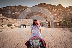 Asian woman tourist riding donkey in Petra, Jordan