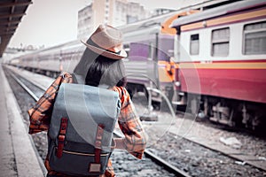 Asian woman tourist standing carrying a backpack. Wait for the train at Hua Lamphong Bangkok Thailand. During his travels in