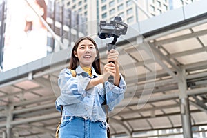 Asian woman tourist travel vlogger taking selfie video in the city photo
