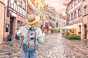 Asian woman tourist traveling with german flag near the famous half-timbered street in Nuremberg old town