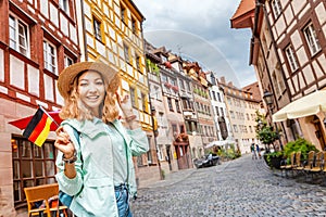 Asian woman tourist traveling with german flag near the famous half-timbered street in Nuremberg old town