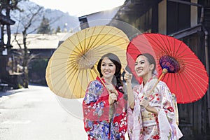 Asian woman tourists. Two Beautiful girl wearing traditional japanese kimono in popular in Old village at Nagano Prefecture, Japan