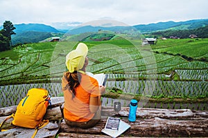 Asian woman travel nature. Travel relax. Standing reading book the balcony of the house. in summer