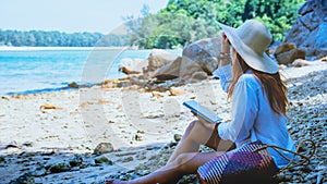 Asian woman travel nature. Travel relax. Study read a book. Nature Education Write a note. On the beach. In the summer. Thailand