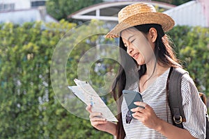 Asian woman traveler backpacker use map and mobile phone app to