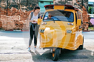 Asian woman travelers ask Tuk-Tuk driver about right direction on the map while exploring travel.