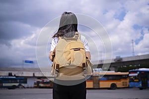 An Asian woman traveling with a backpack By traveling by bus