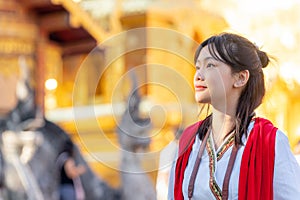 Asian woman traveller intraditional red dress travel in old temple in Chiang mai city