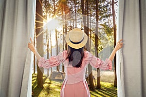 Asian woman traveller open curtain of hotel room for see view