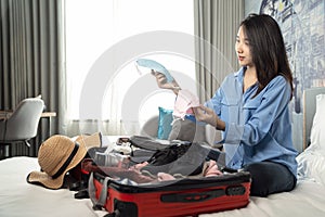 Asian woman traveller select her face mask for travel today in hotel room