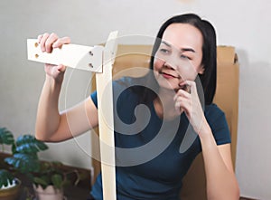 Asian woman  try to assemble knock down furniture and getting confused. Selective focus photo