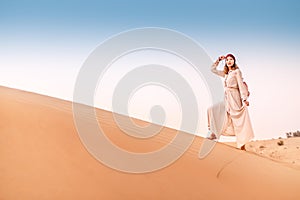 Asian woman in turban travels in Sahara desert. Adventure and life experience concept