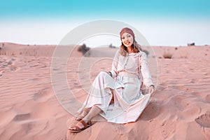 Asian woman in turban travels in Sahara desert. Adventure and life experience concept