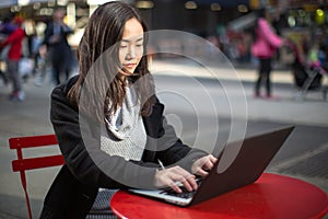 Asian woman typing laptop pc