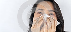 Asian woman, unhappy patient using a tissue to sneeze and blowing her nose in the hospital