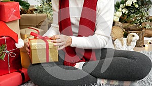 Asian Woman unwrap christmas gift box under xmas tree got surprise present gift.