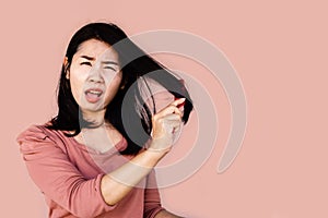 Asian woman using comp brushing her dry damaged long hair photo