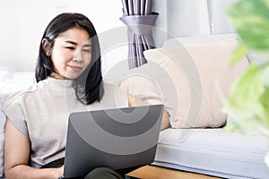 Asian woman using computer laptop , freelancer work online from home office photo