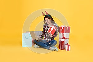 Asian woman using computer for shopping gift box online isolated on yellow background. cyber monday and christmas new year concept