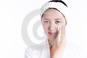 Asian woman using cotton pads, cleaning beautiful face by wiping, cleansing lotion, facial toner. Attractive beautiful young girl