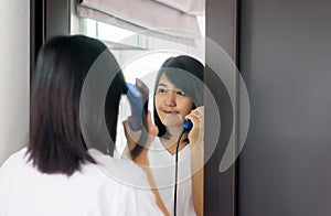 Asian woman using hair irons with straightening