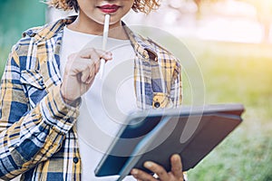 Asian woman using ipad working in garden