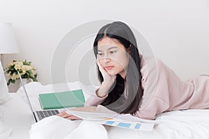 Asian woman using the laptop on the bed,Teenagers use computers in their homes