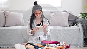 Asian woman using a notebook to review her checklist and packing for a weekend