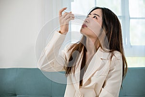 Asian woman using rapid antigen test kit for selftest nose swab test for possible infection