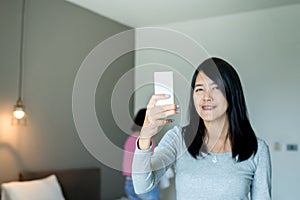 Asian woman using remote control to closed air conditioning at home,Concept save energy and save world
