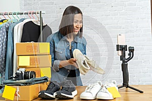 Asian woman using smart mobile phone taking live selling online shoes