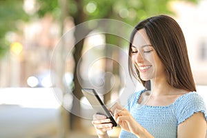 Asian woman using smart phone walking in the street