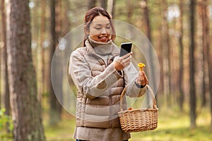 asian woman using smartphone to identify mushroom