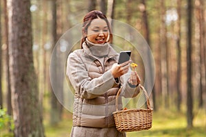 asian woman using smartphone to identify mushroom