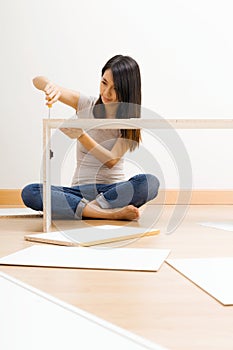 Asian woman using strew drive for assembling closet