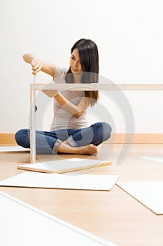 Asian woman using strew drive for assembling closet photo