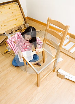 Asian woman using strew driver for chiar assembling