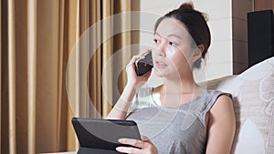 Asian woman using tablet and answer the phone call. Quickly hang up the phone. Incoming call disturb working from home. Short and