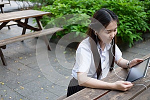 Asian woman using tablet and listening to music