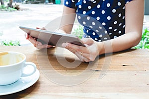 Asian woman using tablet pc on a wood table