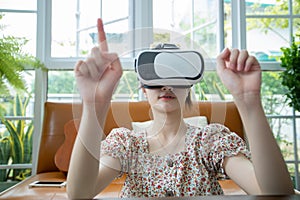 Asian woman using tablet and virtual reality simulator playing games in living room and feeling happy . Lifestyle Senior family at