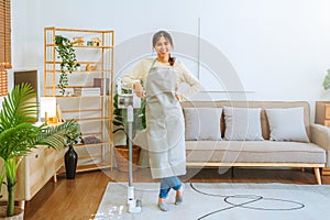 Asian woman using vacuum machine cleaning the floor. housekeeping concept