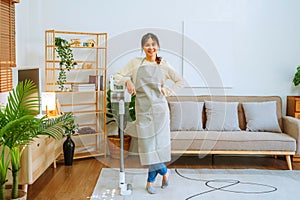 Asian woman using vacuum machine cleaning the floor. housekeeping concept