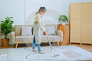 Asian woman using vacuum machine cleaning the floor. housekeeping concept