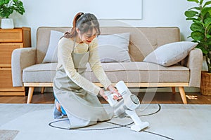 Asian woman using vacuum machine cleaning the floor. housekeeping concept