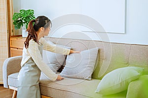 Asian woman using vacuum machine cleaning Sofa. housekeeping concept